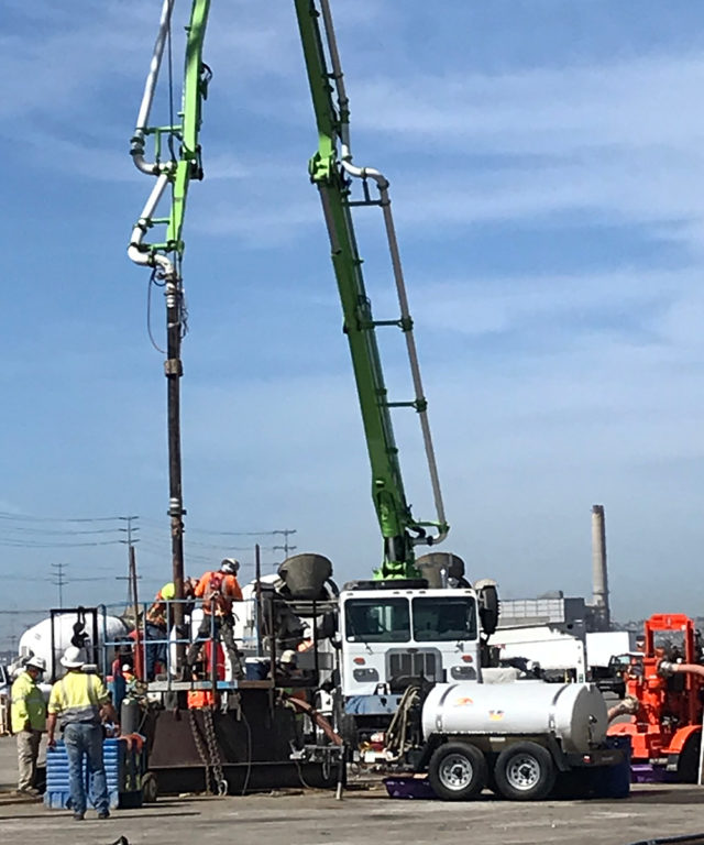 Pouring concrete to secure the rebar in place within the foundations