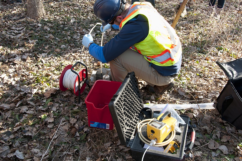 Photo of Haley and Aldrich staff wearing personal protective equipment doing water sampling using equipment.