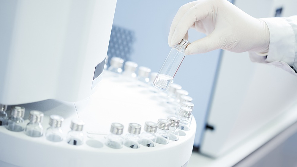 Technician loading sample vials in autosampler rack