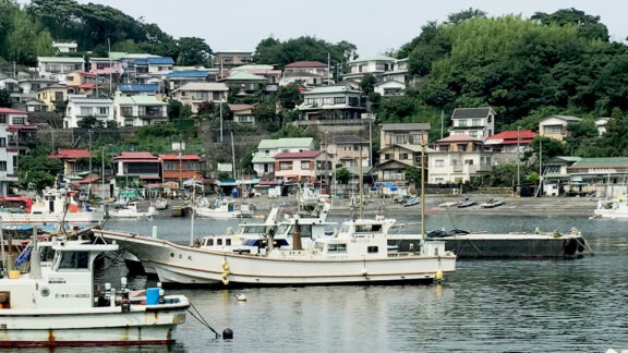 Port with boats and houses on a hill in Japan