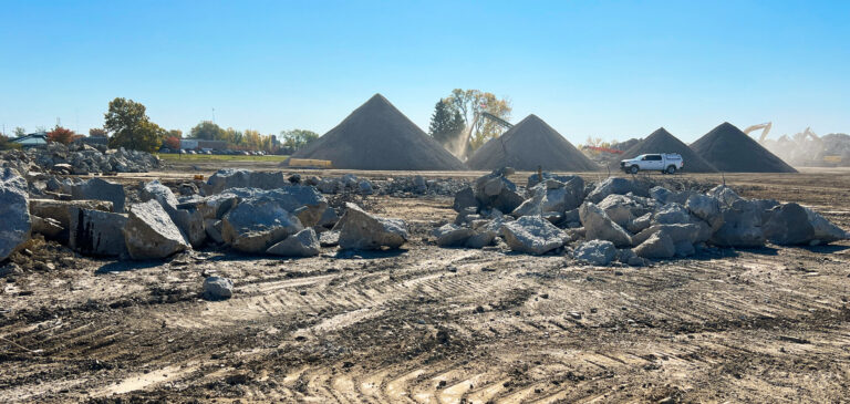 Construction site with large rocks and mounds of dirt.